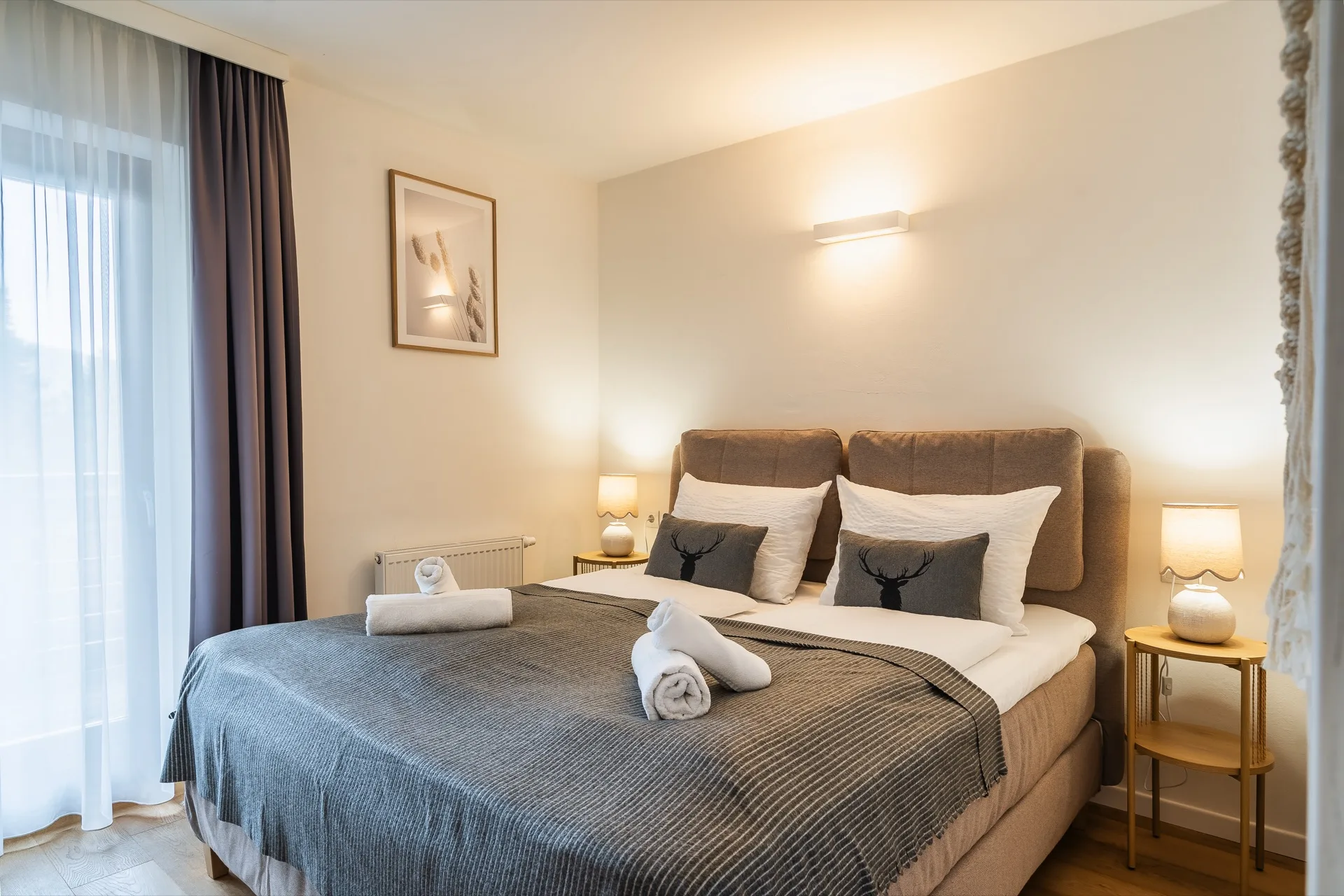Elegantes Schlafzimmer mit Boxspringbett, gefalteten Handtüchern und Alpenmotiv-Kissen im Rosie Design Chalet Brunnach Bad Kleinkirchheim – Ferienwohnung Fotografie Kärnten – Mathias Prägant Photography