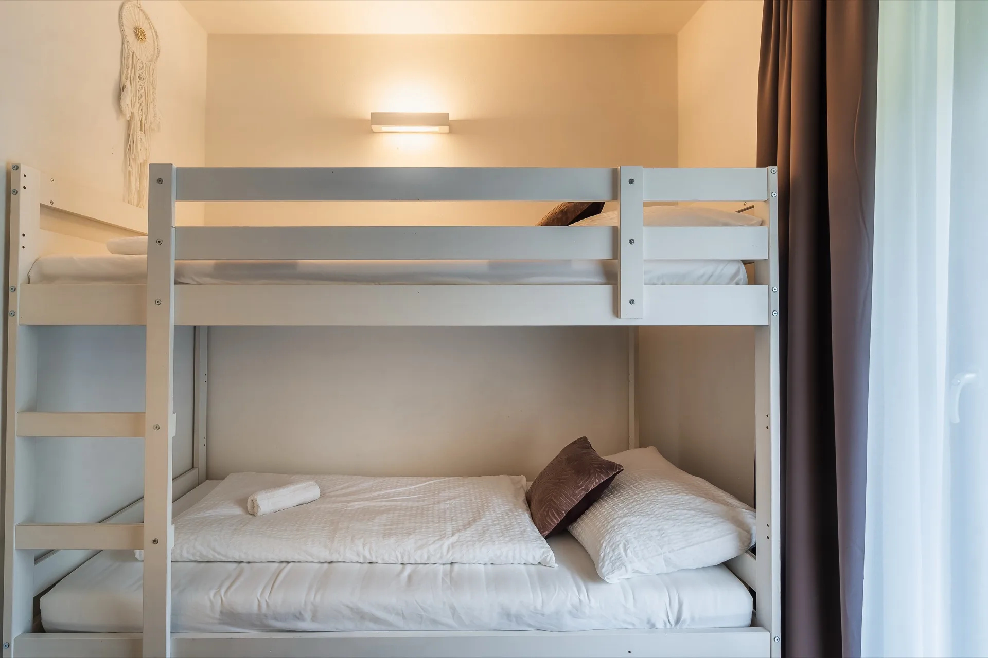 Helles Kinderzimmer mit weißem Etagenbett, großem Fenster und Dreamcatcher im Rosie Design Chalet Brunnach Bad Kleinkirchheim – familienfreundliche Ferienwohnung Fotografie Kärnten – Mathias Prägant Photography