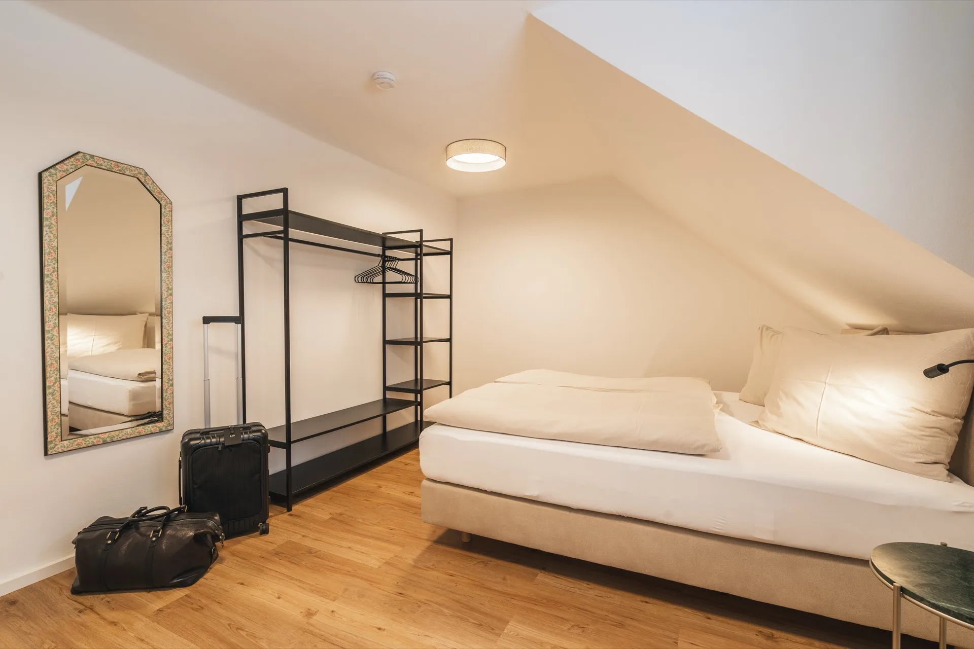 Helles Schlafzimmer mit charmantem Dachschrägen-Charakter und modernem offenem Kleiderschrank im Appartement Nr.16 Landhaus Apartments Prägant Bad Kleinkirchheim – gemütlich und stilvoll, Ferienwohnung Fotografie Kärnten